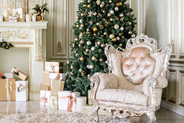 Mañana de Navidad. Apartamentos de lujo clásicos con árbol de Navidad decorado y regalos. Vivir con chimenea, columnas y estuco . — Foto de Stock