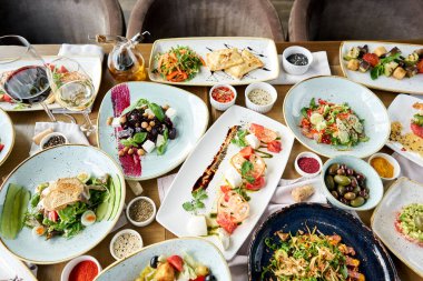 Tabakların çeşitleri masada. Masada çeşitli abur cuburlar ve antipastalar var. Restoran menüsü. İtalyan mutfağı