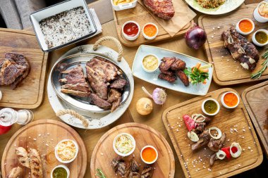 Barbekü restoranı menüsü. Masada bir sürü farklı yemek var. Akşam yemeği ya da ziyafet. Üst görünüm
