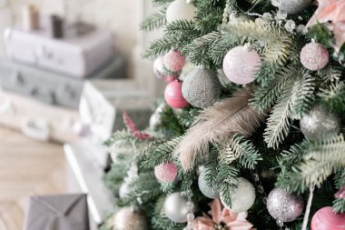 Noel ağacının süslemeli dalları. Noel baloları, kurdele yayı, kar taneleri, çam kozalakları ve ışıklar.