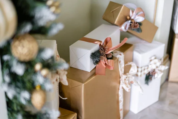 Ağacın altında bir sürü süslemeli Noel hediyesi var. Noel baloları, kurdele yayı, kar taneleri, çam kozalakları ve ışıklar. — Stok fotoğraf