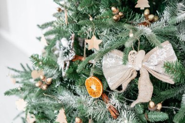 Noel ağacının süslemeli dalları. Noel baloları, kurdele yayı, kar taneleri, çam kozalakları ve ışıklar.