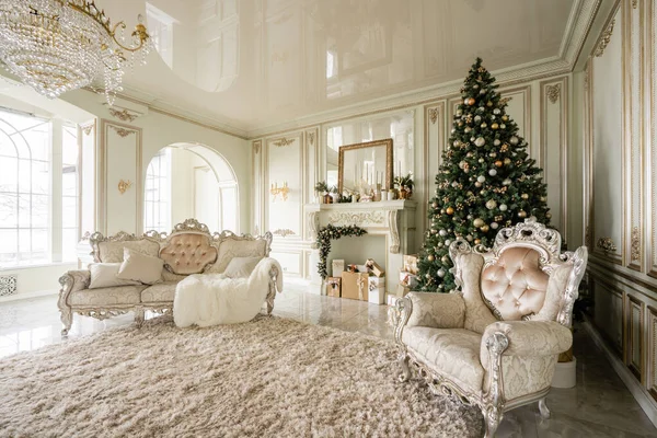 Mañana de Navidad. Apartamentos de lujo clásicos con árbol de Navidad decorado y regalos. Vivir con chimenea, columnas y estuco . — Foto de Stock