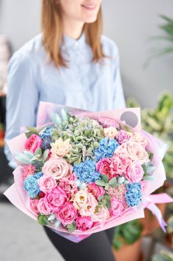 Kadın elinde karışık çiçek güzel buket. Çiçek dükkanı konsepti . Yakışıklı taze buket. Çiçek teslimatı. Kırmızı ve pembe renk.