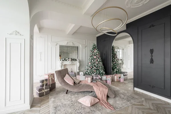 Mañana de Navidad. Apartamentos de lujo clásicos con árbol de Navidad decorado y regalos. Vivir con chimenea, columnas y estuco . — Foto de Stock