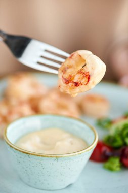 Mango-jalapeno soslu ızgara Arjantin karidesi. Bir restoranda öğle yemeği, bir kadın lezzetli ve sağlıklı yiyecekler yer. Taze sebze ve limonlu lezzetli deniz ürünleri karidesleri. Krema sosu