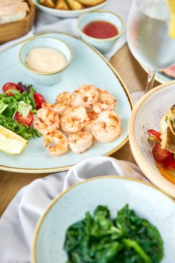 Roka ve limonlu karides. Bbq deniz ürünleri. Restoran menüsü. Tabakların çeşitleri masada. Restoran menüsü.