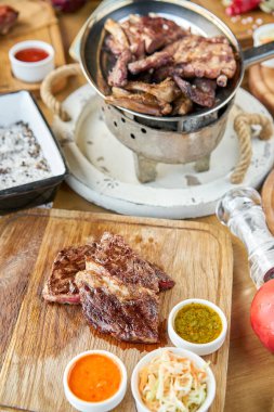 Orta pişmiş ızgara biftekli pirzola. Barbekü restoranı menüsü. Masada bir sürü farklı yemek var. Akşam yemeği ya da ziyafet.