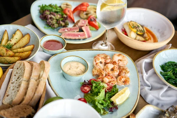 Assiettes barbecue aux fruits de mer avec garniture. Variété de plats sur la table. Menu restaurant . — Photo