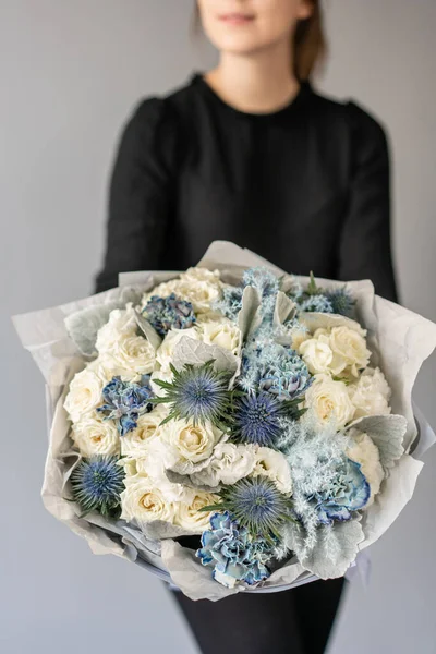 Couleur blanche et bleue. Beau bouquet de fleurs mélangées dans les mains des femmes. le travail du fleuriste dans un magasin de fleurs. Fleurs fraîches coupées . — Photo