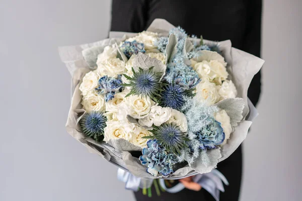 Color blanco y azul. Hermoso ramo de flores mixtas en manos de mujeres. el trabajo de la floristería en una florería. Flor fresca cortada . — Foto de Stock