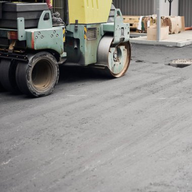 Asfalt Kompaktörleri yol onarımı yapıyor. Yeni asfalt seriyorum. Büyük, ağır makineler. Yeni bir asfalt yol inşaatı.