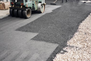 Asfalt Kompaktörleri yol onarımı yapıyor. Yeni asfalt seriyorum. Büyük, ağır makineler. Yeni bir asfalt yol inşaatı.