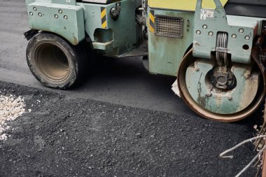 Asfalt Kompaktörleri yol onarımı yapıyor. Yeni asfalt seriyorum. Büyük, ağır makineler. Yeni bir asfalt yol inşaatı.