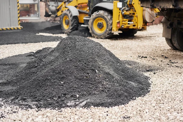 Montón nuevo asfalto caliente. Colocando asfalto, cubriendo la fosa, sobre los escombros. Asfalto Compactadores está llevando a cabo trabajos de reparación de carreteras . — Foto de Stock