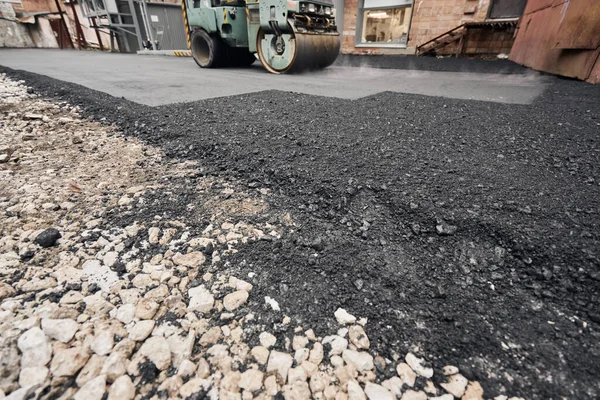 Asphalt Compactors está llevando a cabo trabajos de reparación de carreteras. Colocando asfalto nuevo. Maquinaria pesada grande. Construcción de una nueva carretera de asfalto . — Foto de Stock