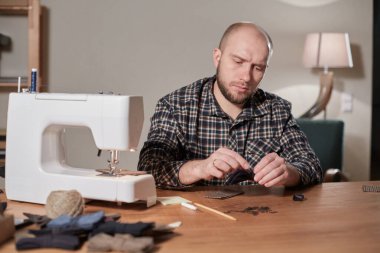 Terzi yün kumaştan papyon yapar. Tekstil atölyesinde dikiş makinesiyle çalışıyorum..