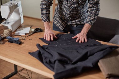 Terzi yün kesim kumaşı. Çizgi deseni. El sanatları ustası yün kumaştan papyonlar için dikdörtgen boşluklar yapıyor. Tekstil atölyesinde dikiş makinesiyle çalışıyorum..