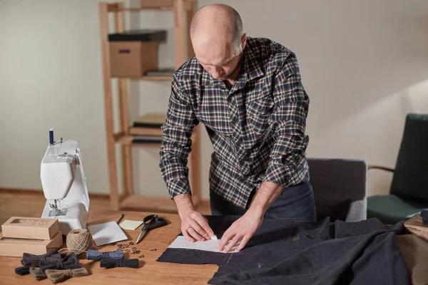 Terzi yün kesim kumaşı. Çizgi deseni. El sanatları ustası yün kumaştan papyonlar için dikdörtgen boşluklar yapıyor. Tekstil atölyesinde dikiş makinesiyle çalışıyorum..