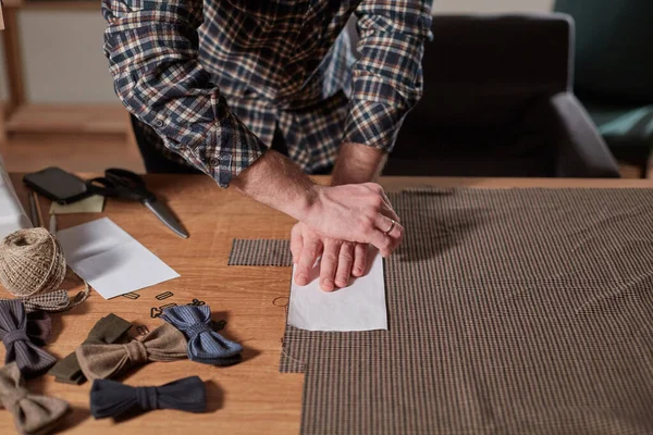 裁缝师的特写手，剪羊毛面料。 工匠用毛织物做长方形的领结. 与纺织厂的缝纫机一起工作. — 图库照片