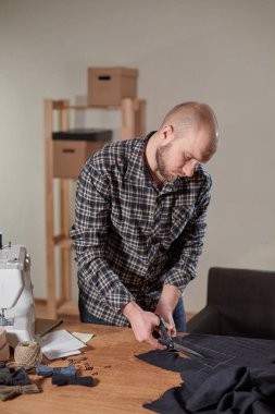 Terzi yün kesim kumaşı. Çizgi deseni. El sanatları ustası yün kumaştan papyonlar için dikdörtgen boşluklar yapıyor. Tekstil atölyesinde dikiş makinesiyle çalışıyorum..