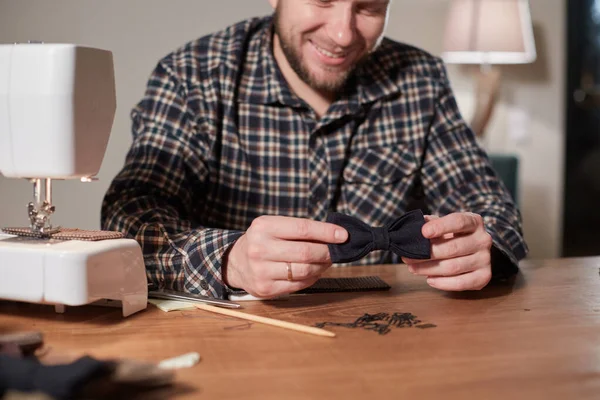 Terzi yün kumaştan papyon yapar. Tekstil atölyesinde dikiş makinesiyle çalışıyorum..