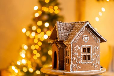 Zencefilli kek evi, Noel tatili konsepti ve mutlu yıllar. Noel ağacının odaksız ışıkları. Parlak oturma odasında sabah. Tatil havası..