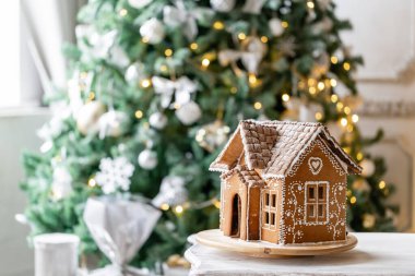 Zencefilli kek evi, Noel tatili konsepti ve mutlu yıllar. Noel ağacının odaksız ışıkları. Parlak oturma odasında sabah. Tatil havası..