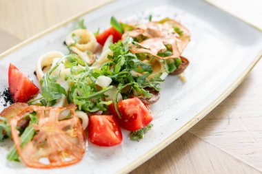 Taze Salata domates, fesleğen, mozzarella ve ahşap arka plan üzerinde zeytinyağı ile. İtalyan geleneksel caprese salatası. Akdeniz, doğal ve organik gıda konsepti.