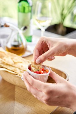 Kadın leziz Matzo yiyor. Domates ve tatlı biber sosuyla servis edilir. Matzo, matza veya matza, Yahudi mutfağının bir parçası olan mayasız ekmek.