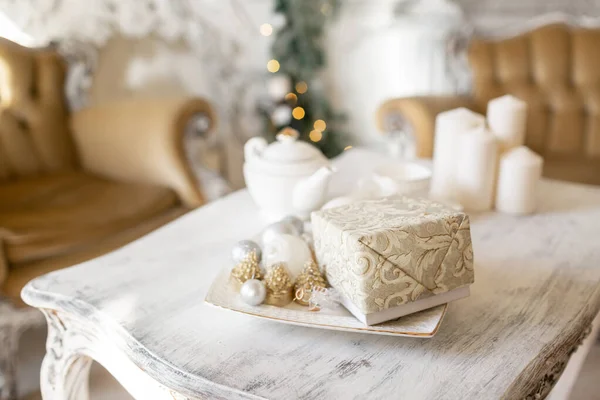 Χρόνος τσαγιού, λευκή τσαγιέρα και φλιτζάνια στο τραπέζι. Στολισμένο χριστουγεννιάτικο δέντρο. Κλασικά διαμερίσματα με τζάκι λευκό. — Φωτογραφία Αρχείου