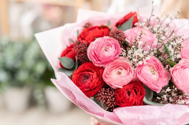 Kadınların elinde güzel bir buket karışık çiçek. Çiçekçi dükkanındaki çiçekçinin işi. Güzel, taze bir buket. Çiçek teslimatı