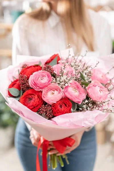 Hermoso ramo de flores mixtas en manos de mujeres. el trabajo de la floristería en una florería. Bonito ramo fresco. Entrega de flores — Foto de Stock