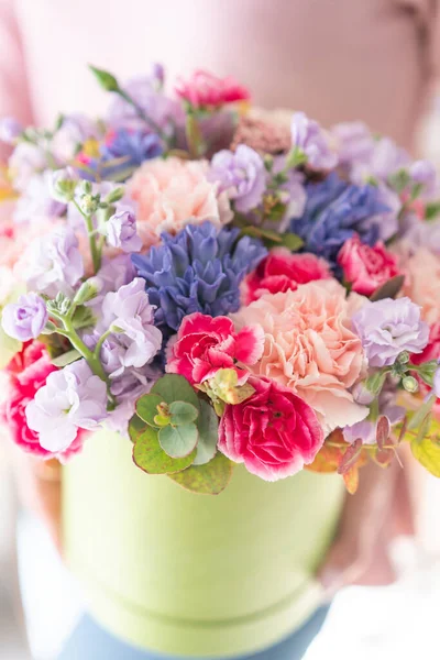 Loja floral europeia. Bando floral em caixa redonda. Buquê de belas flores mistas na mão da mulher. Excelentes flores do jardim no arranjo, o trabalho de um florista profissional . — Fotografia de Stock