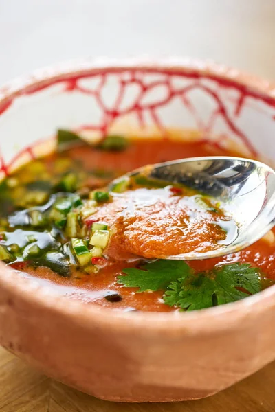 Closeup gaspacho soup in bowl. Traditional spanish cold soup puree gaspacho or gazpacho on wooden table