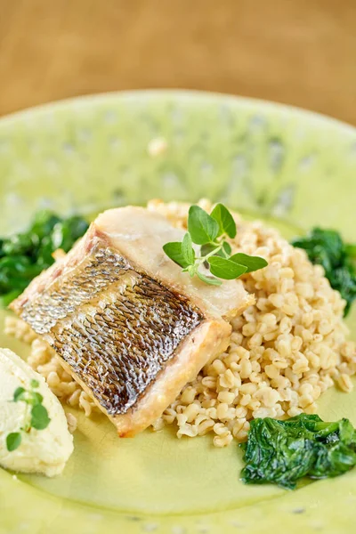 Roasted Pike perch with spelt and Polish sauce. Dish decorated with a spinach. Restaurant menu — Stock Photo, Image