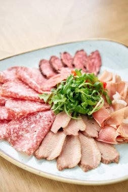 Yakın çekim et tabağı, lezzet ve Anantipasto. Salam, biftek, Parma jambonu, füme ördek göğsü. Restoran menüsü.
