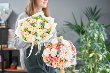 Kadın elinde karışık çiçek iki güzel buketleri. bir çiçekçi de çiçekçi çalışmaları. Taze kesilmiş çiçek.