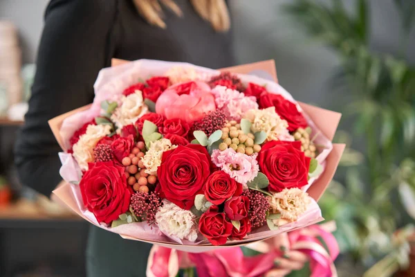 Tons vermelhos Belo buquê de flores mistas em mãos de mulheres. o trabalho da florista em uma loja de flores. Bonito buquê fresco. Entrega de flores — Fotografia de Stock