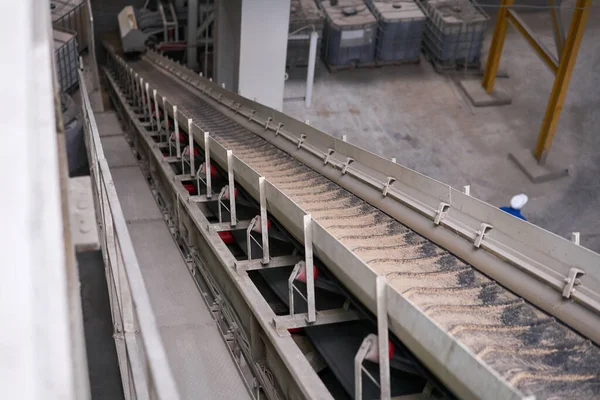 Karıştırıcıdaki malzemelerin taşıyıcı bandı. House-Building fabrikasının atölyesinde çalışanlar. Endüstriyel iç mekan. Beton fabrikası.