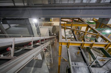 Karıştırıcıdaki malzemelerin taşıyıcı bandı. House-Building fabrikasının atölyesinde çalışanlar. Endüstriyel iç mekan. Beton fabrikası.