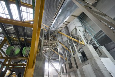 Büyük endüstriyel karıştırıcı, sıvı çimento ile karıştırmak için House-Building fabrikasının atölyesindeki işçiler. Endüstriyel iç mekan. Beton fabrikası.