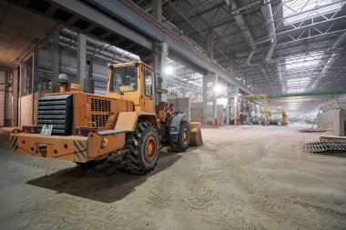 Nizhny Novgorod, Rusya - 30 Ekim 2019. Bitki Km Precast. Büyük inşaat makineleri, traktör kum döküyor. House-Building fabrikasının atölyesi. Endüstriyel iç mekan. Beton fabrikası.
