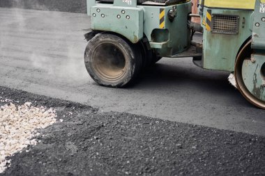 Asfalt Kompaktörleri yol onarımı yapıyor. Yeni asfalt seriyorum. Büyük, ağır makineler. Yeni bir asfalt yol inşaatı.