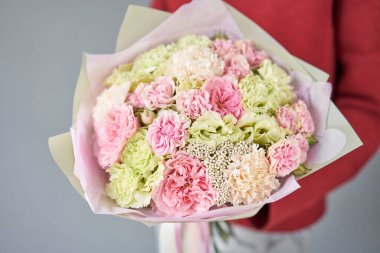Avrupa çiçekçisi. Kadınların elinde güzel bir buket karışık çiçek. Çiçekçi dükkanındaki çiçekçinin işi. Taze kesilmiş çiçek getirdim..