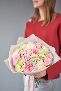 Avrupa çiçekçisi. Kadınların elinde güzel bir buket karışık çiçek. Çiçekçi dükkanındaki çiçekçinin işi. Taze kesilmiş çiçek getirdim..