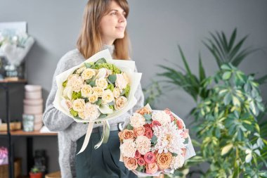 Kadın elinde karışık çiçek iki güzel buketleri. bir çiçekçi de çiçekçi çalışmaları. Taze kesilmiş çiçek.