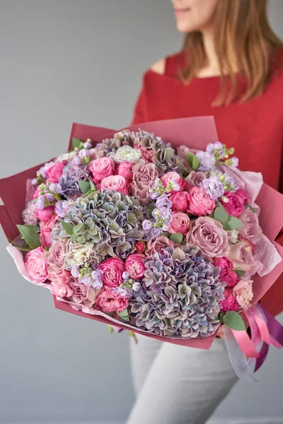 European floral shop. Beautiful bouquet of mixed flowers in womans hands. the work of the florist at a flower shop. Delivery fresh cut flower. — Stock Photo, Image