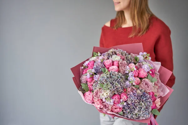 European floral shop. Beautiful bouquet of mixed flowers in womans hands. the work of the florist at a flower shop. Delivery fresh cut flower. — Stock Photo, Image