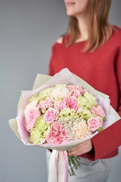 Negozio floreale europeo. Bellissimo bouquet di fiori misti nelle mani delle donne. il lavoro del fioraio in un negozio di fiori. Consegna fresco fiore reciso . — Foto Stock